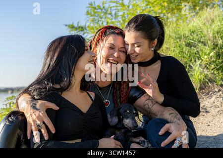 Famille heureuse de trois femmes et chien profitant du temps ensemble, rire et se lier Banque D'Images