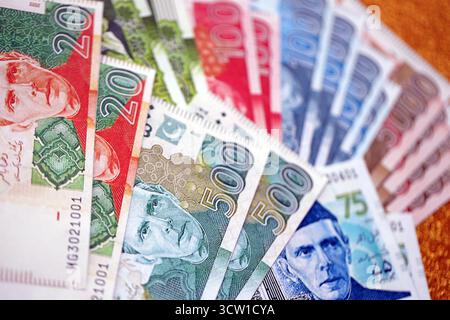Pakistan roupies billets de banque sur fond jaune doré. Les factures d'argent pakistanaises actuelles sont sur la table en gros montant. Le concept d'affaires et d'investissement au Pakistan Banque D'Images