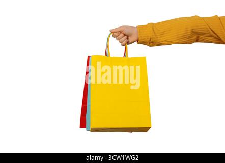 Gros plan d'une main tenant des sacs à provisions lumineux sur un fond blanc, symbolisant les concepts de vente au détail, de shopping et de consommation. Banque D'Images