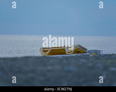 Chaises longues empilées sur Rocky Beach Banque D'Images