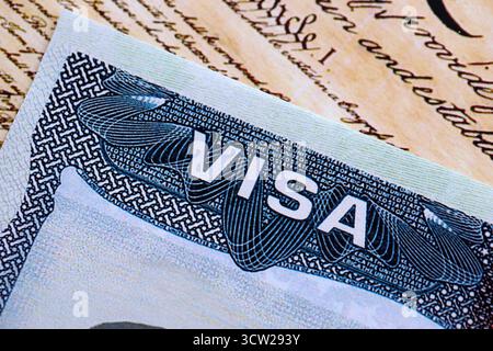 Vue rapprochée d'un visa américain estampillé sur une page de passeport avec fond de Constitution américaine. Concept de voyage et d'immigration Banque D'Images