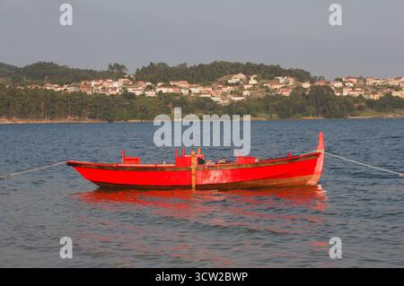 Bateau à rames en bois rouge attaché dans le port de Combarro Galicia Espagne Banque D'Images
