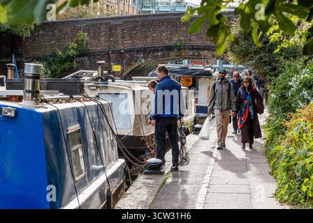 Bateaux étroits et piétons marchant sur le chemin de halage du Regent's canal à Wenlock Basin, Londres, Royaume-Uni Banque D'Images