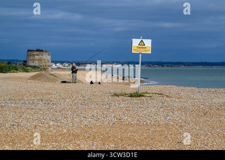 Un homme à la retraite pêchant en mer depuis la plage d'Eastbourne, en Angleterre Banque D'Images