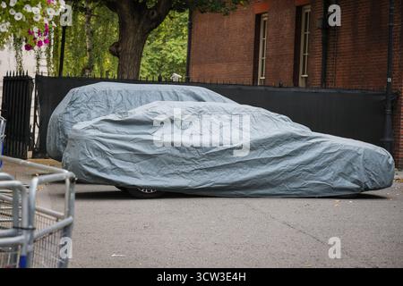 Londres, Royaume-Uni. 09 octobre 2025. Deux voitures du parc gouvernemental sont garées, à l'abri de la poussière et des intempéries sous une couverture de voiture. Avec le PM absent en Inde et le Parlement ne siégeant pas pendant la saison des conférences, Downing Street a connu une journée tranquille avec peu d'activité. La pause se termine le lundi 13 octobre. Crédit : Imageplotter/Alamy Live News Banque D'Images