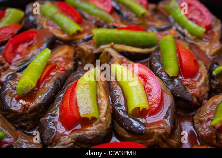 Un gros plan copieux et invitant présente un plateau de moitiés d'aubergines magnifiquement cuites, généreusement farcies d'une garniture salée Banque D'Images