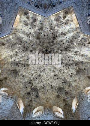 GRENADE, ESPAGNE – 4 OCTOBRE 2025 : plafond complexe de muqarnas à l'intérieur du palais de l'Alhambra présentant des détails architecturaux islamiques. Banque D'Images