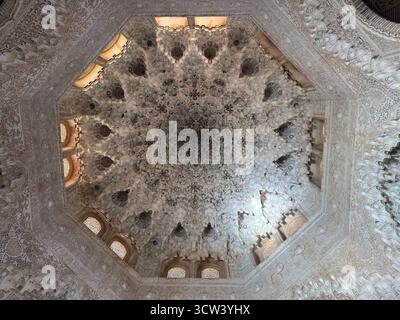 GRENADE, ESPAGNE – 4 OCTOBRE 2025 : plafond complexe de muqarnas à l'intérieur du palais de l'Alhambra présentant des détails architecturaux islamiques. Banque D'Images