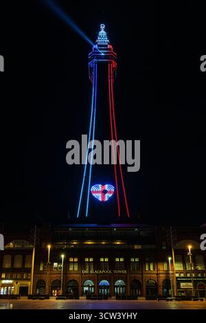 la tour emblématique de blackpool, illuminée de nuit en rouge et en bleu, émet un faisceau de lumière depuis le sommet et affiche un signe de cœur de l'union jack Banque D'Images
