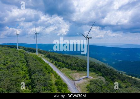 Vue aérienne des éoliennes debout contre le ciel, surplombant la verdure luxuriante des montagnes, Mount Storm, Virginie occidentale, États-Unis. Banque D'Images