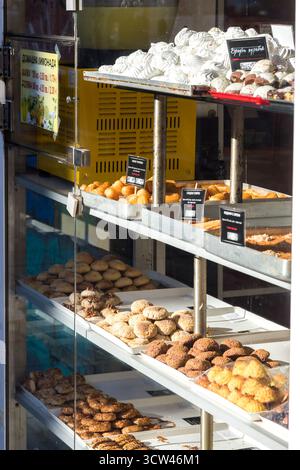 Assortiment de pâtisseries exposées dans une vitrine de boulangerie pendant une journée ensoleillée Banque D'Images