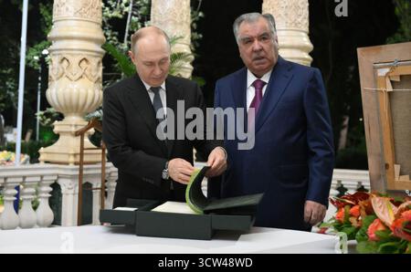 Douchanbé, Tadjikistan. 09 octobre 2025. Le président russe Vladimir Poutine, à gauche, visionne le livre d'or aux côtés du président tadjik Emomali Rakhmon, à droite, avant un dîner informel au jardin botanique Iram, le 8 octobre 2025 à Douchanbé, au Tadjikistan. Poutine est au Tadjikistan pour le 2ème Sommet d'Asie centrale. Crédit : Grigory Sysoev/Kremlin Pool/Alamy Live News Banque D'Images