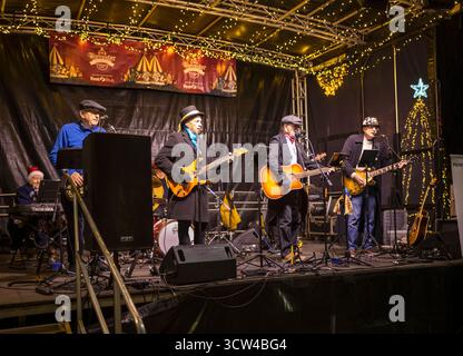 Worcestershire, Angleterre-novembre 29 2024 : un groupe local joue sur une scène temporaire, sur la place de la cathédrale, en face du monument historique dans l'oreille Banque D'Images
