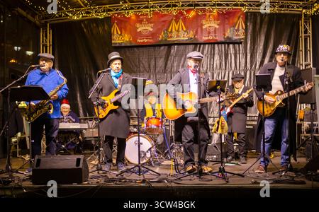 Worcestershire, Angleterre-novembre 29 2024 : un groupe local joue sur une scène temporaire, sur la place de la cathédrale, en face du monument historique dans l'oreille Banque D'Images