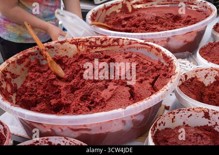 Pâte de tomate maison dans de grands récipients. Pâte de tomate fraîche traditionnelle à vendre sur un marché Banque D'Images