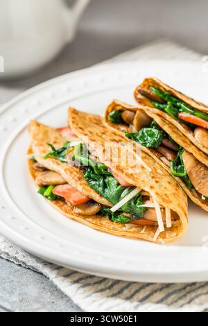 Crêpes françaises salées maison avec épinards et champignons Banque D'Images