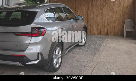Une BMW moderne argentée aux lignes épurées, un toit noir et des feux arrière à LED distinctifs, est garée dans une allée Banque D'Images