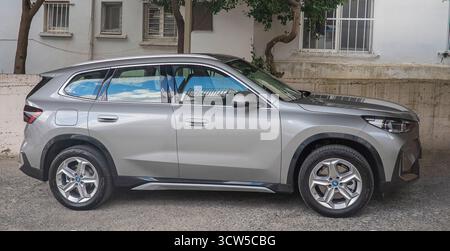 Une BMW moderne argentée aux lignes épurées, un toit noir et des feux arrière à LED distinctifs, est garée dans une allée Banque D'Images