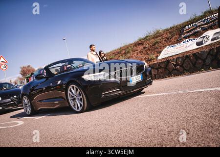 Rome, italie 10 septembre 2025 : la bmw z4 cabriolet noire s'arrête lors d'une rencontre ensoleillée avec des spectateurs admirant l'élégante voiture de sport de luxe à toit ouvert de i Banque D'Images