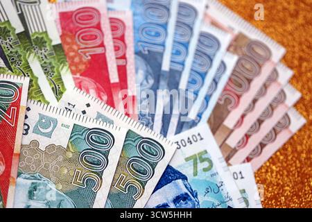 Pakistan roupies billets de banque sur fond jaune doré. Les factures d'argent pakistanaises actuelles sont sur la table en gros montant. Le concept d'affaires et d'investissement au Pakistan Banque D'Images