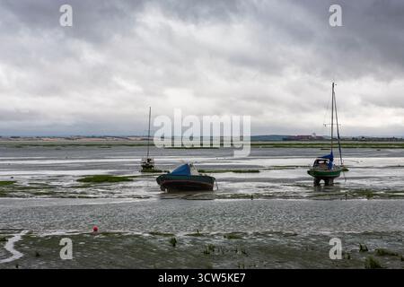 Estuaire de la Tamise à marée basse, avec des bateaux secs et hauts à Leigh Creek et un grand porte-conteneurs descendant la rivière au-delà : Leigh-on-Sea, Essex, Royaume-Uni Banque D'Images