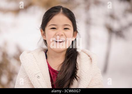 Fille philippine souriante dans la neige Banque D'Images