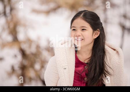 Heureuse fille philippine et hispanique dans la neige à Tahoe Banque D'Images