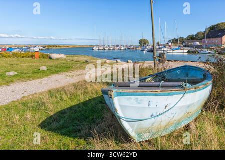 Marina à Norsminde, village sur la côte de la mer Baltique près d'Aarhus, Danemark. Un vieux bateau de pêche au premier plan. Banque D'Images