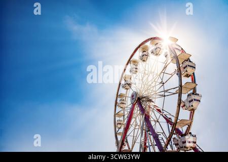 Grande roue contre le ciel bleu et l'éruption de soleil Banque D'Images