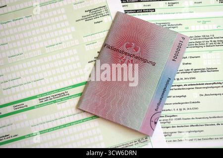 Le spécimen de carte de résident permanent temporaire allemand se trouve sur le formulaire fiscal allemand close up. Fiktionsbescheinigung et einkommensteuerklarung Banque D'Images