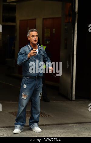 Londres, Royaume-Uni, 10 octobre 2025. Robbie Williams quitte la BBC et prend des vidéos avec des fans après être apparu sur BBC Radio 1 Live Lounge. Crédit : Ben Shaw/Alamy Live News Banque D'Images