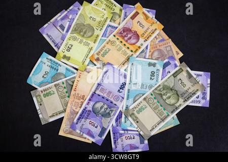 tas de billets de banque colorés en roupie indienne sur fond noir Banque D'Images