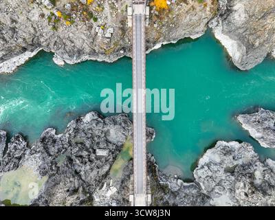 Vue aérienne montrant un long pont en bois enjambant l'étroite gorge turquoise de la rivière, entouré de formations rocheuses grises à motifs Banque D'Images