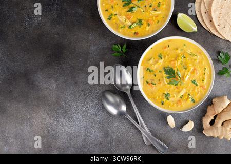 Soupe traditionnelle indienne Mulligatawny avec lentilles et poulet sur fond sombre. Vue de dessus. Copier l'espace Banque D'Images