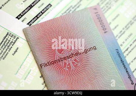 Le spécimen de carte de résident permanent temporaire allemand se trouve sur le formulaire fiscal allemand close up. Fiktionsbescheinigung et einkommensteuerklarung Banque D'Images