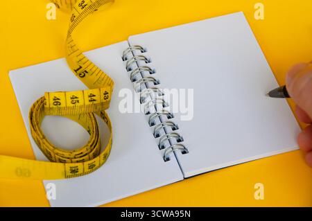 Ruban de mesure diététique avec cahier vierge Banque D'Images