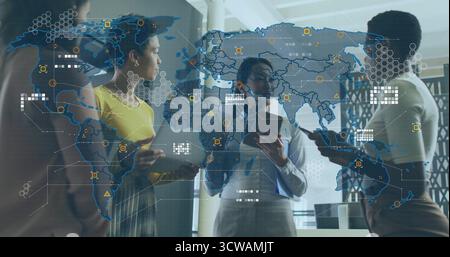 Femmes collaborant dans des vêtements d'affaires tenant des dispositifs de geste vers la carte holographique dans le bureau Banque D'Images