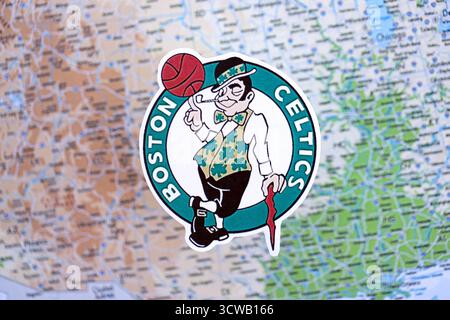 KIEV, UKRAINE - 23 FÉVRIER 2025 L'insigne de l'équipe de basket-ball des Boston Celtics se trouve sur la bannière de fond de la carte des États-Unis Banque D'Images