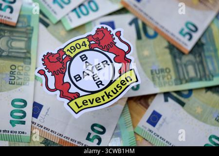 KIEV, UKRAINE - 23 FÉVRIER 2025 Bayer 04 Leverkusen football badge se trouve sur un grand montant de centaines d'EUROS DE billets d'argent Banque D'Images
