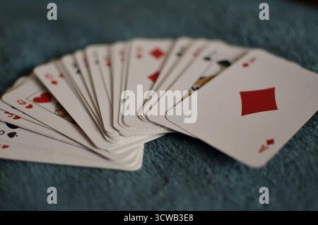 Un jeu de cartes à jouer est dispersé sur le sol, en arrière-plan. Banque D'Images