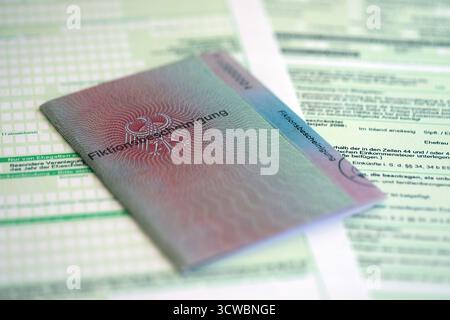 Le spécimen de carte de résident permanent temporaire allemand se trouve sur le formulaire fiscal allemand close up. Fiktionsbescheinigung et einkommensteuerklarung Banque D'Images