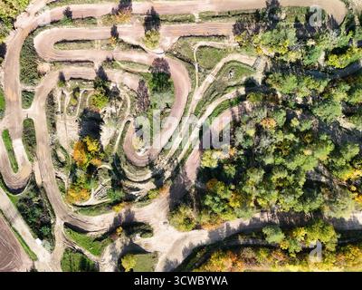 Vue aérienne d'une piste de motocross avec des chemins de terre sinueux et un environnement naturel Banque D'Images