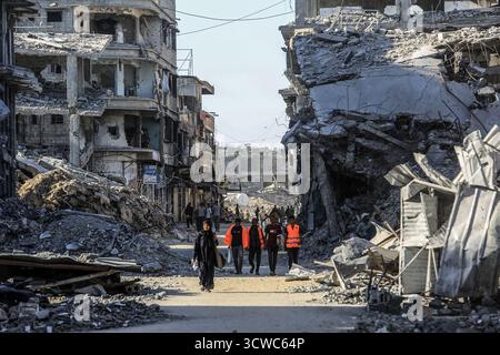 Khan Yunis, Territoires palestiniens. 11 octobre 2025. Les gens marchent à travers les ruines de Khan Younis, alors que les Palestiniens déplacés rentrent chez eux après le retrait de l’armée israélienne et l’entrée en vigueur du cessez-le-feu. Crédit : Abed Rahim Khatib/dpa/Alamy Live News Banque D'Images