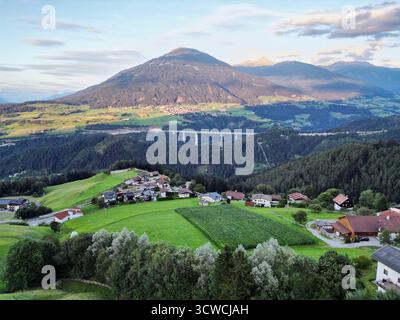 Drone aérien vue de la vallée alpine près d'Innsbruck avec Mountain Road Bridge et maisons de village Banque D'Images