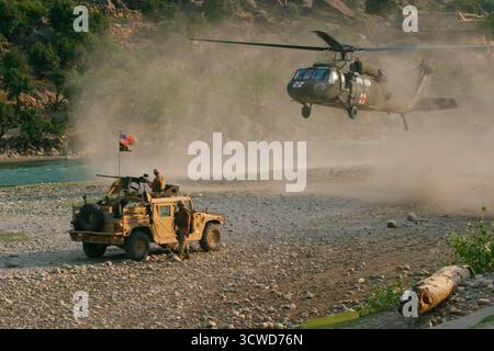 CAMP BLESSING, AFGHANISTAN - 25 juin 2004 - les Marines américains avec le 1er peloton, la compagnie Kilo et les forces spéciales de l'armée américaine maintiennent un périmètre de sécurité alors qu'un hélicoptère UH-60 Black Hawk décolle pour une évacuation médicale au sud de Camp Blessing, Afghanistan - photo : Geopix/USMC/Justin Mason Banque D'Images
