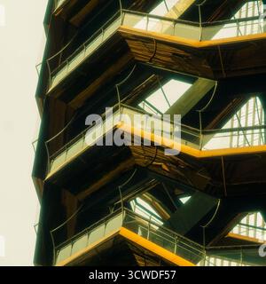 Gros plan abstrait d'une structure architecturale moderne avec des lignes géométriques et des balcons superposés en plein soleil Banque D'Images