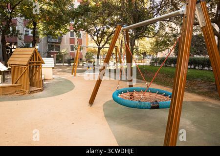 Balançoire de panier rond vide sur une aire de jeux calme dans la ville Description : une aire de jeux urbaine moderne avec un panier rond SW Banque D'Images