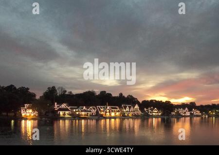 Le soleil se lève à travers les nuages derrière Boathouse Row historique sur la rivière Schuylkill à Philadelphie, PA. Banque D'Images