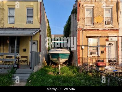 Un bateau se trouve entre les rowhomes dans le quartier Ogontz de Philadelphie. Banque D'Images