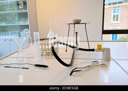 Divers outils de chimie et verrerie disposés dans un laboratoire scolaire pour des expériences scientifiques et des leçons pratiques. Banque D'Images